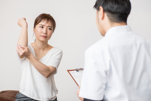 右腕の関節を診てもらう女性